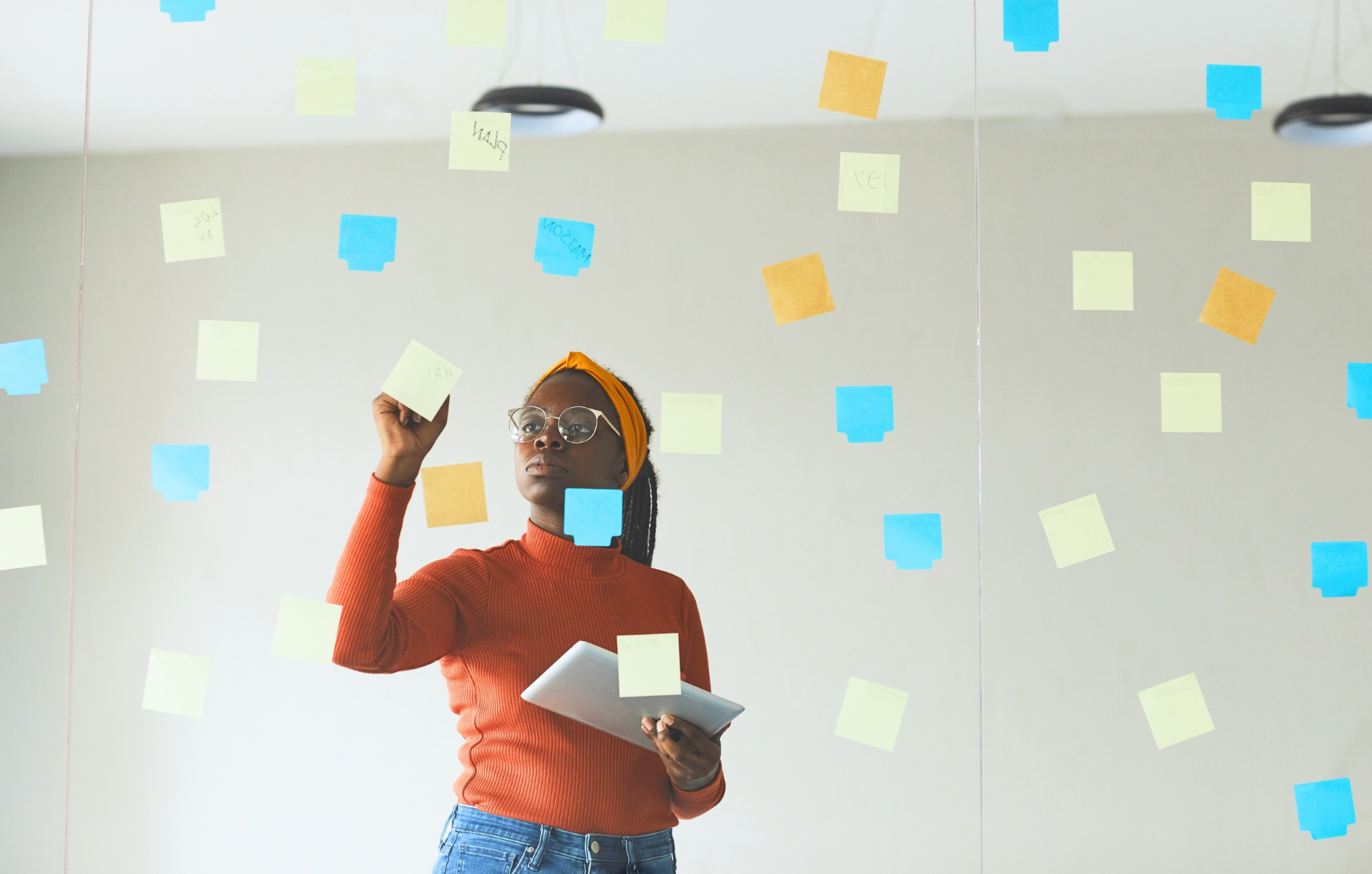 Woman organizing thoughts on sticky notes while overcoming overthinking and indecision.